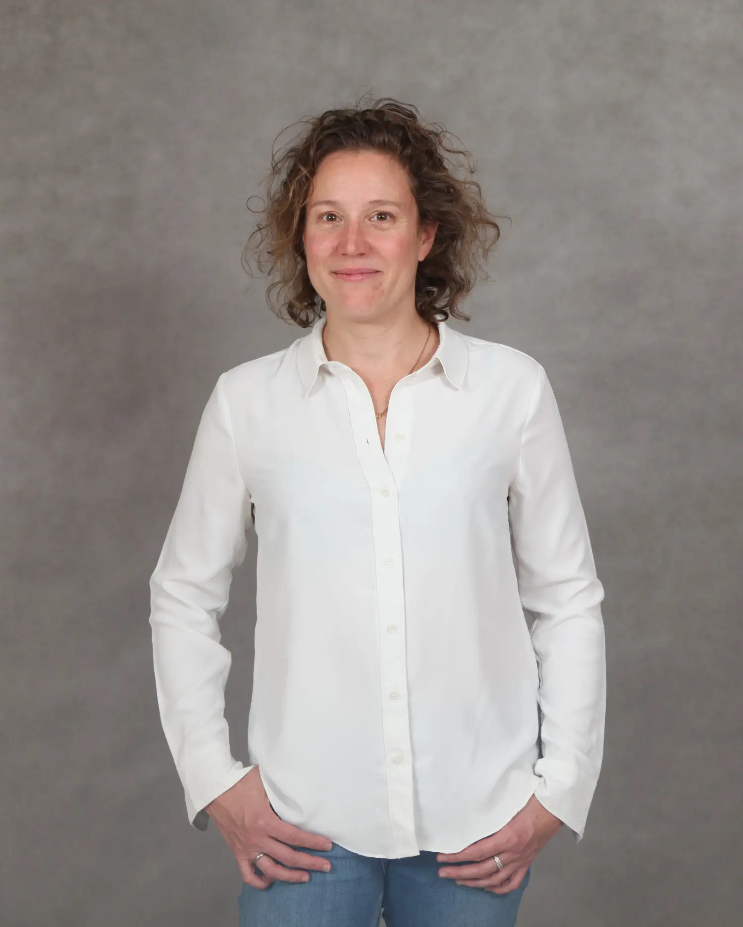 Frau mit lockigen Haaren in weißer Bluse